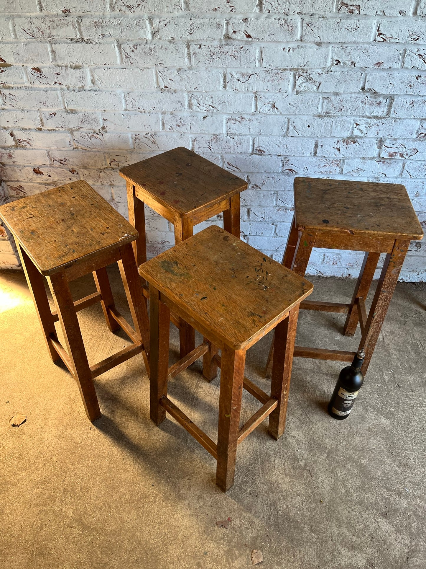 Set of four tall vintage oak school/lab/factory stools with old paint.