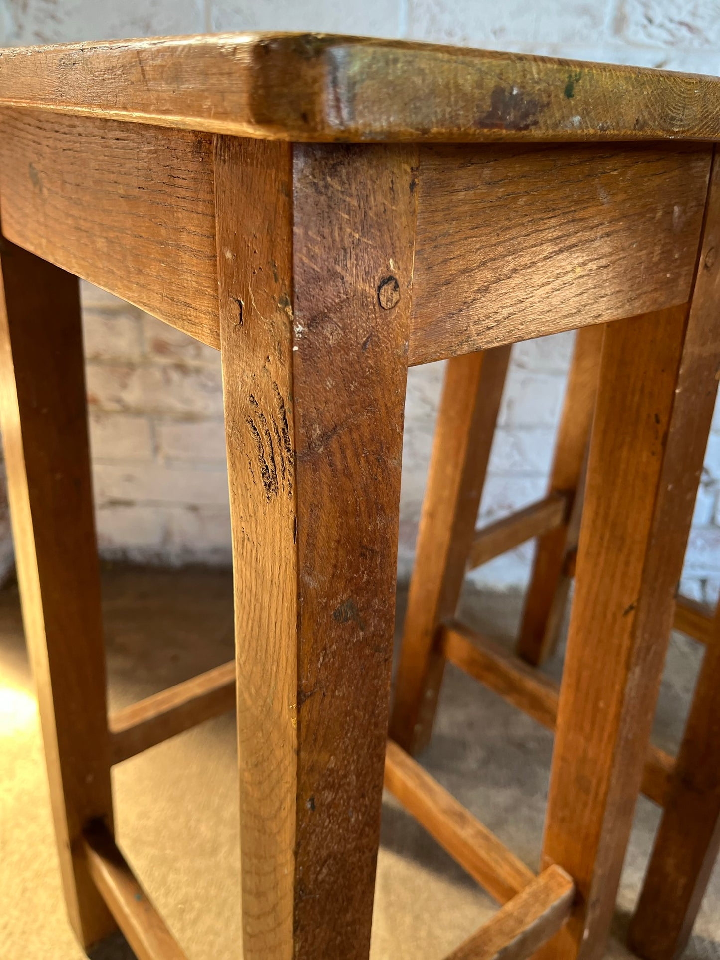 Set of four tall vintage oak school/lab/factory stools with old paint.