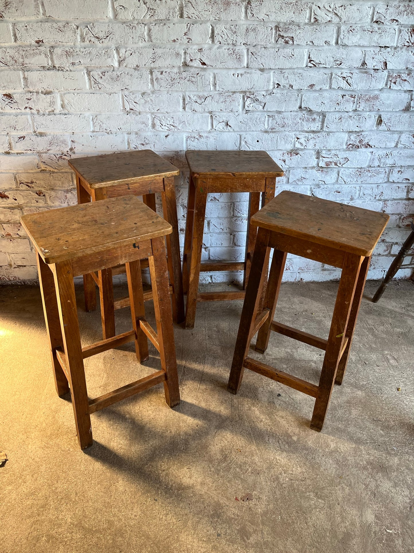 Set of four tall vintage oak school/lab/factory stools with old paint.