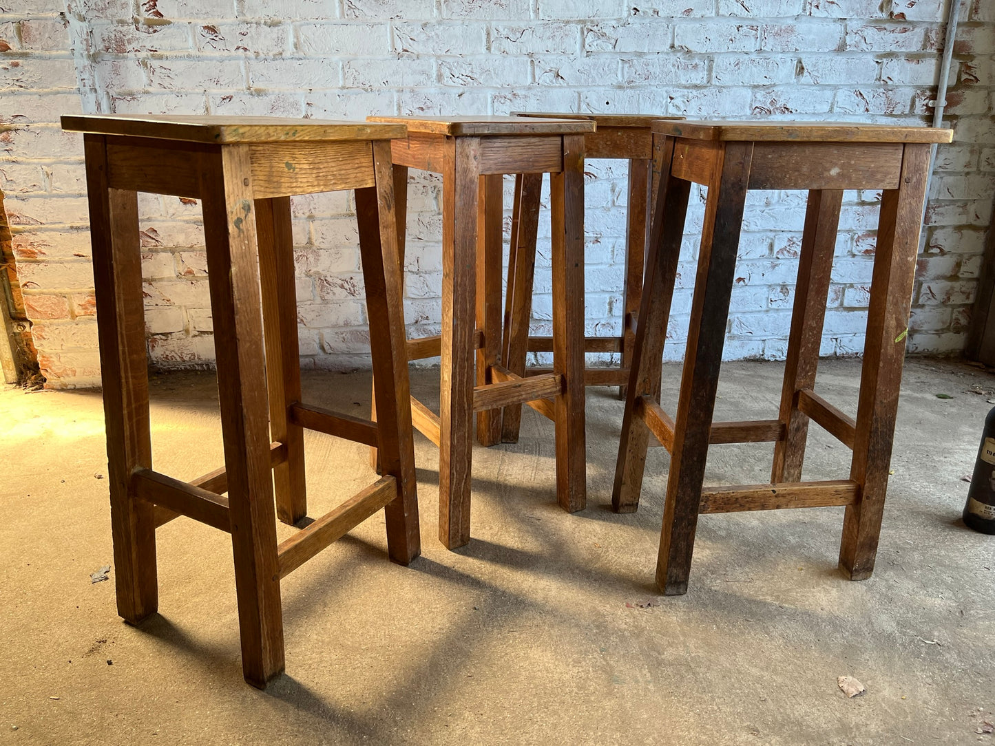 Set of four tall vintage oak school/lab/factory stools with old paint.