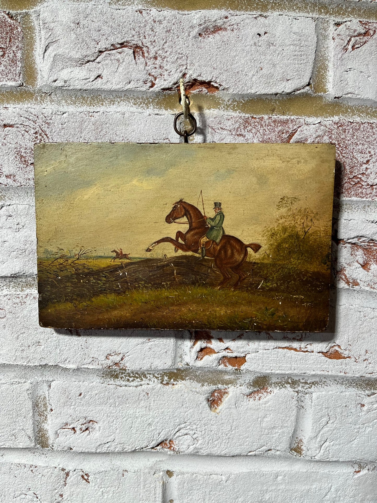19th century English naive school oil on board of horse and rider taking a fence.