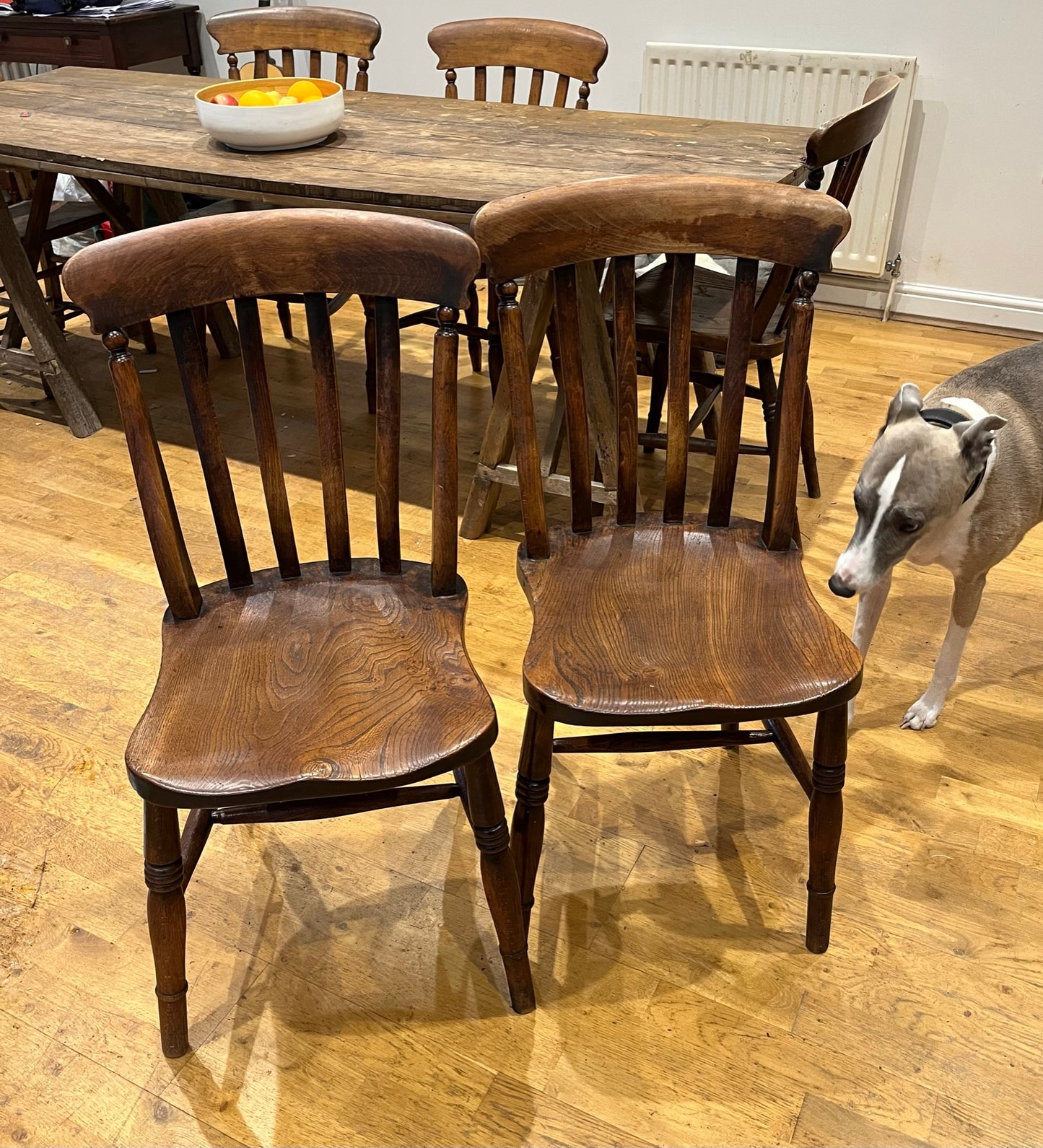 A pair of elm Windsor slat back country kitchen chairs.