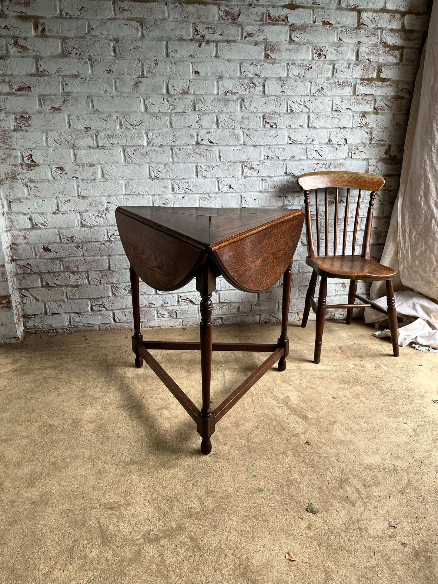 Late 19th/early 20th century oak cricket table with drop flap top.