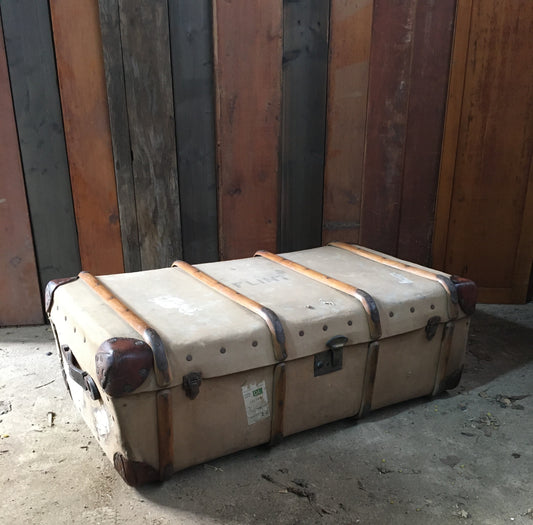 Untouched vintage steamer travel trunk with labels.