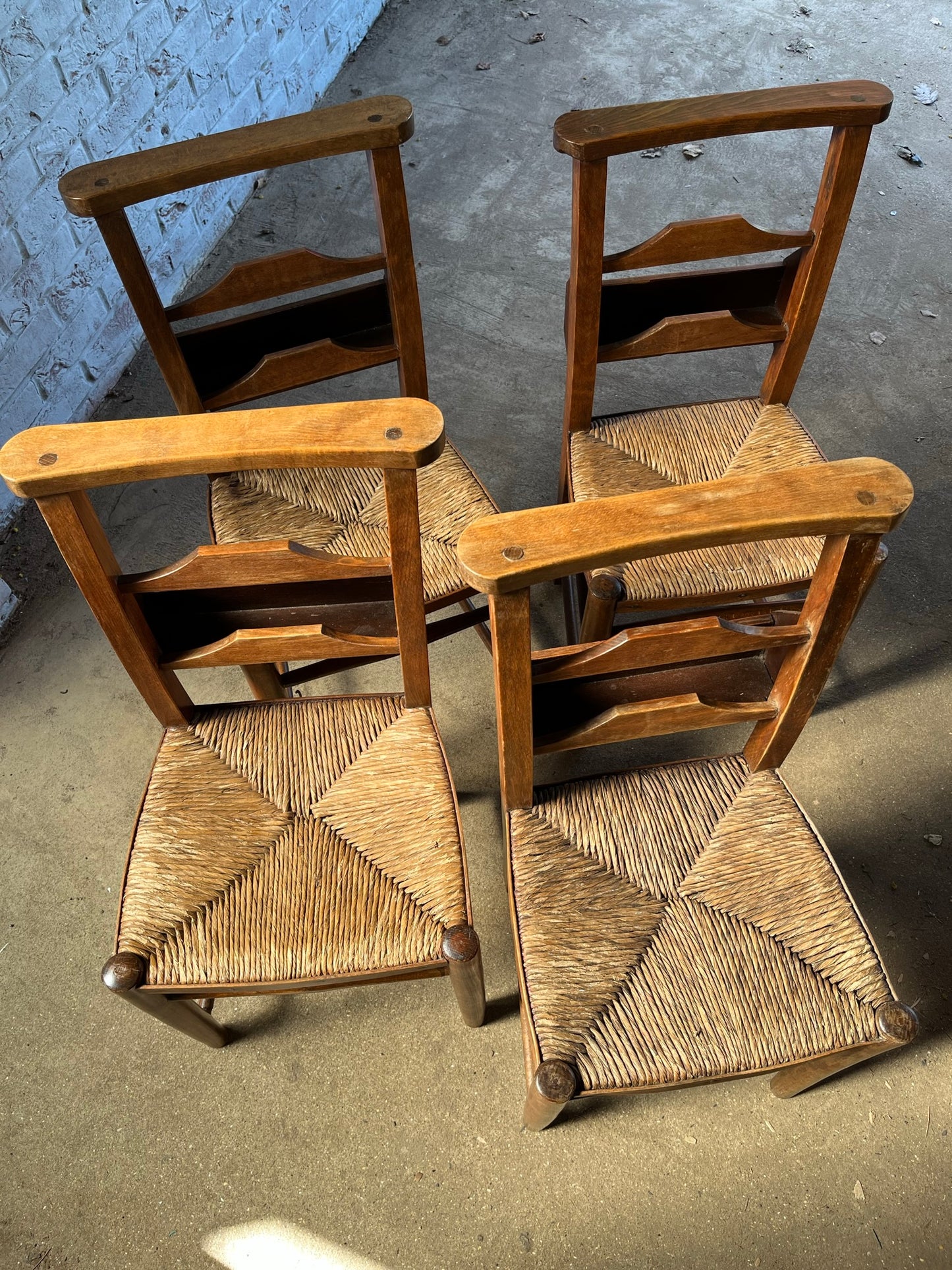 Set of four rustic early 20th century ladder back chapel chairs.