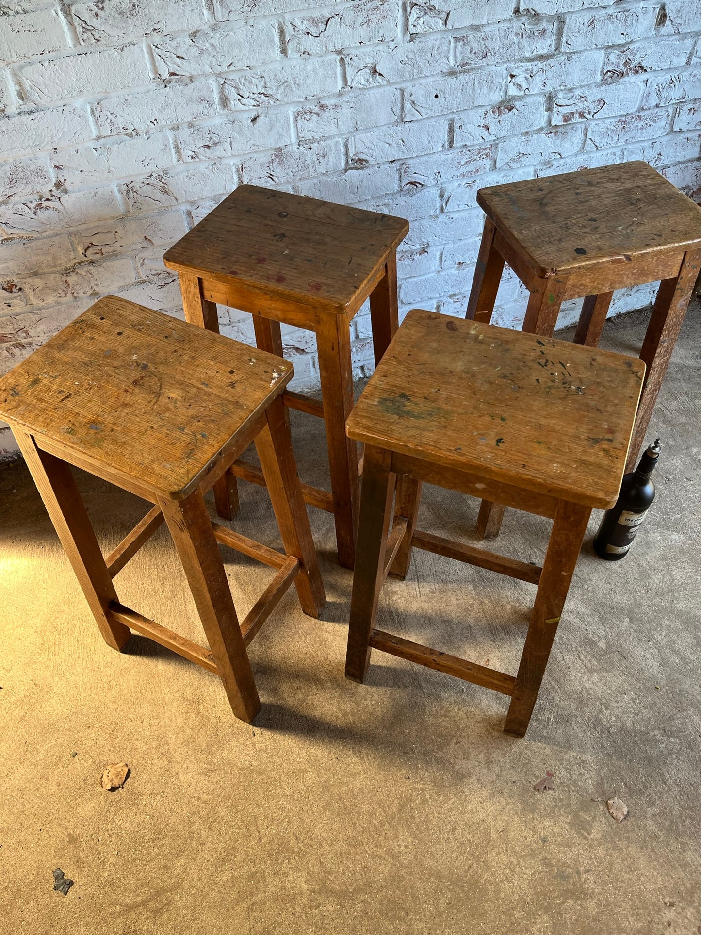 Set of four tall vintage oak school/lab/factory stools with old paint.