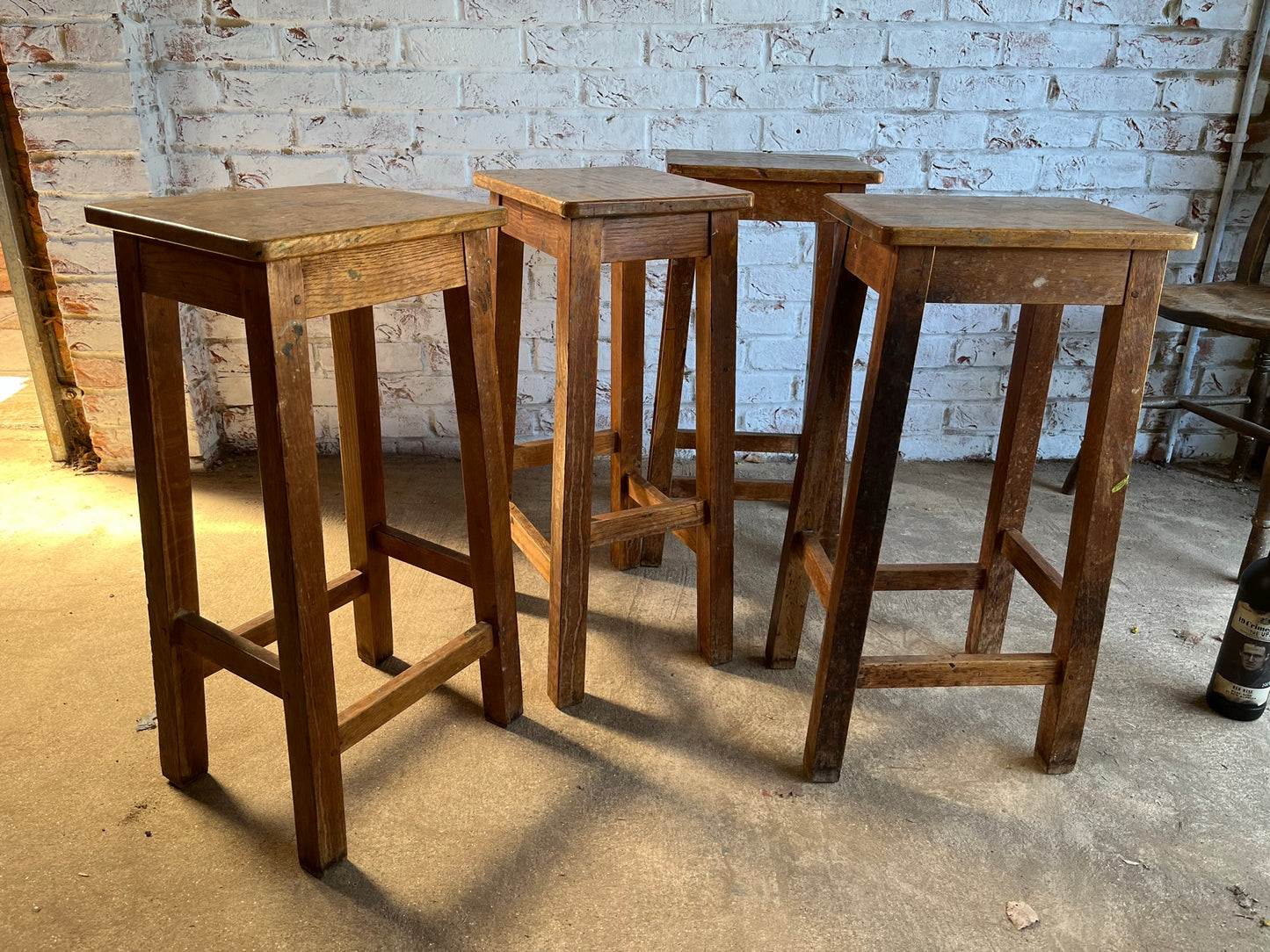 Set of four tall vintage oak school/lab/factory stools with old paint.