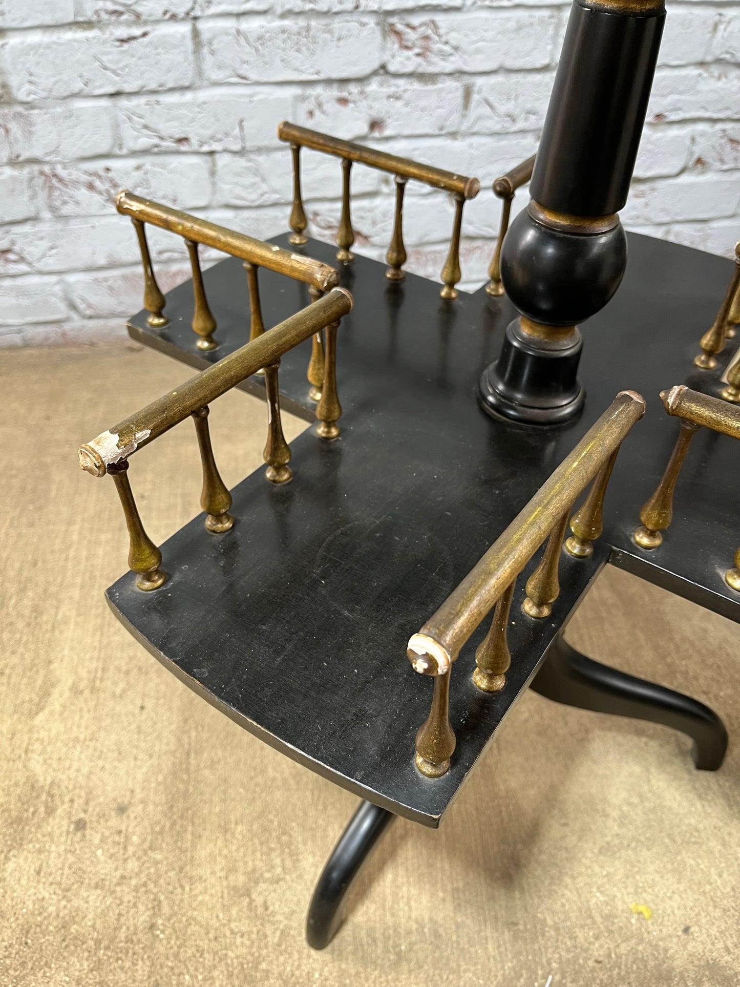 Ebonised and gilt revolving book table with candle holder.