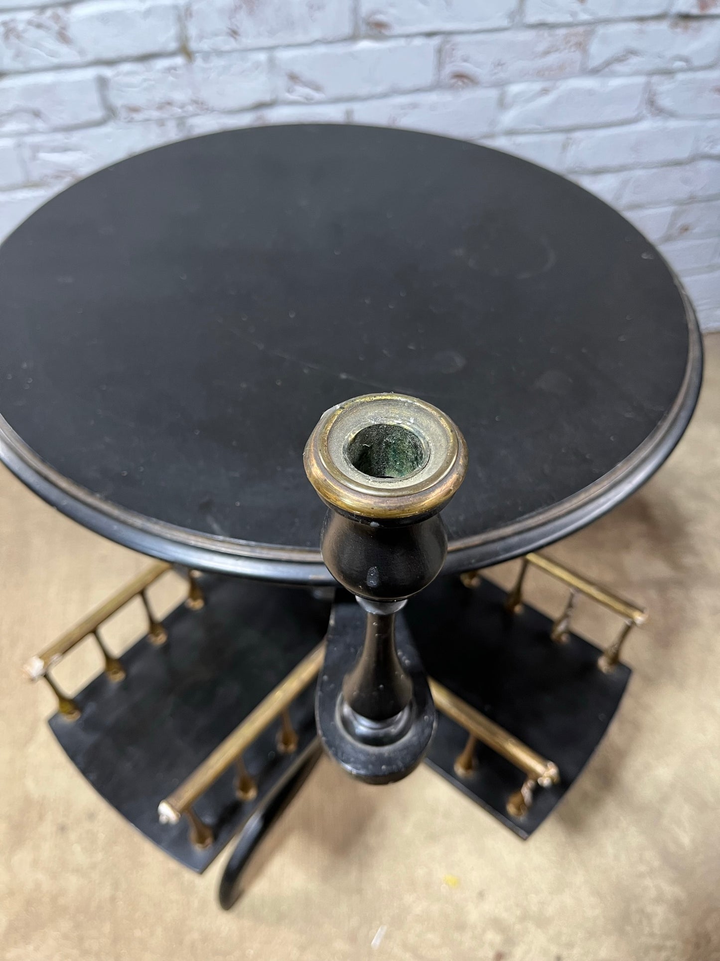 Ebonised and gilt revolving book table with candle holder.