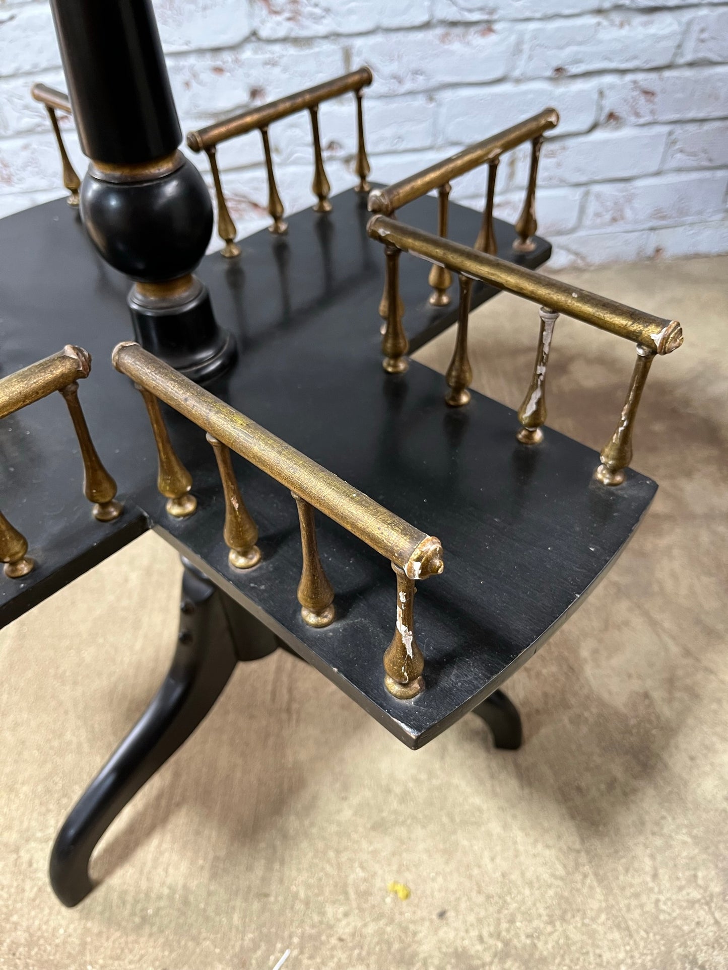Ebonised and gilt revolving book table with candle holder.