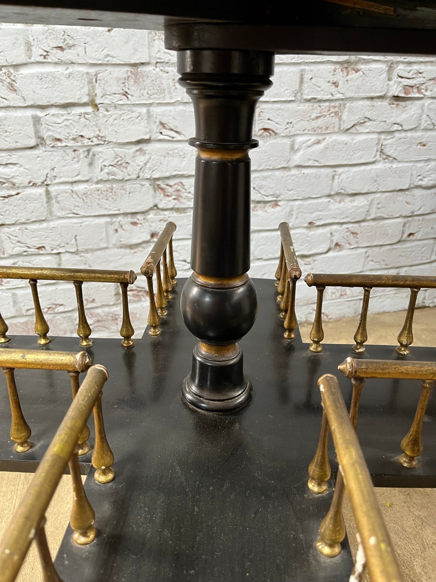 Ebonised and gilt revolving book table with candle holder.