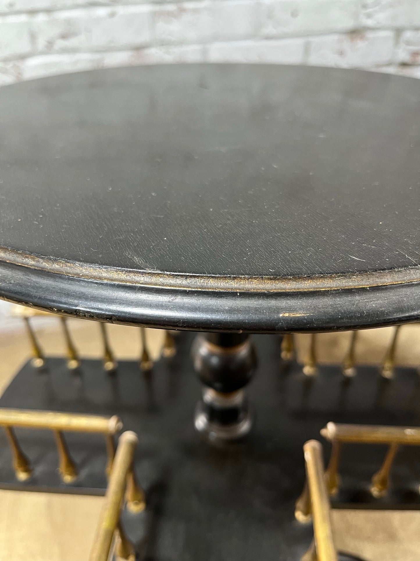 Ebonised and gilt revolving book table with candle holder.