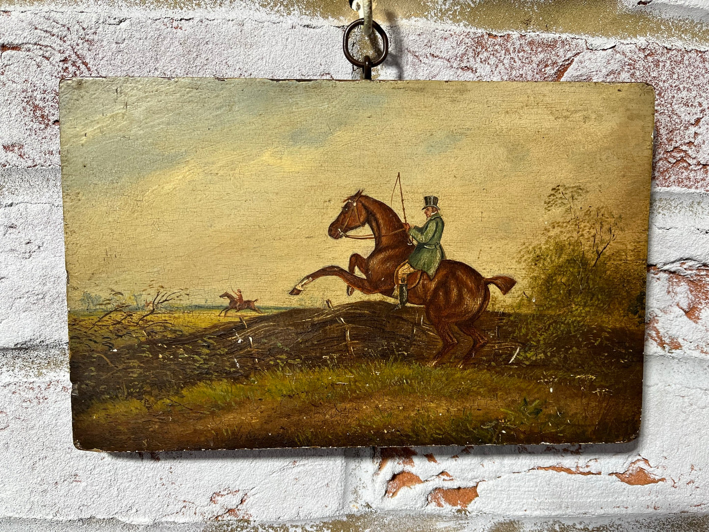 19th century English naive school oil on board of horse and rider taking a fence.