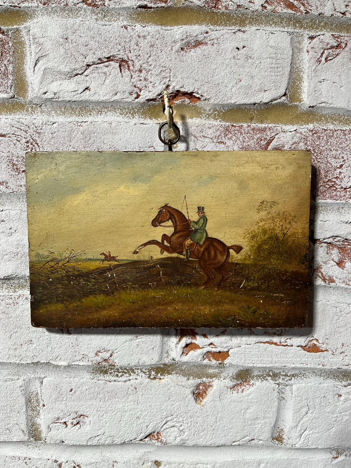 19th century English naive school oil on board of horse and rider taking a fence.