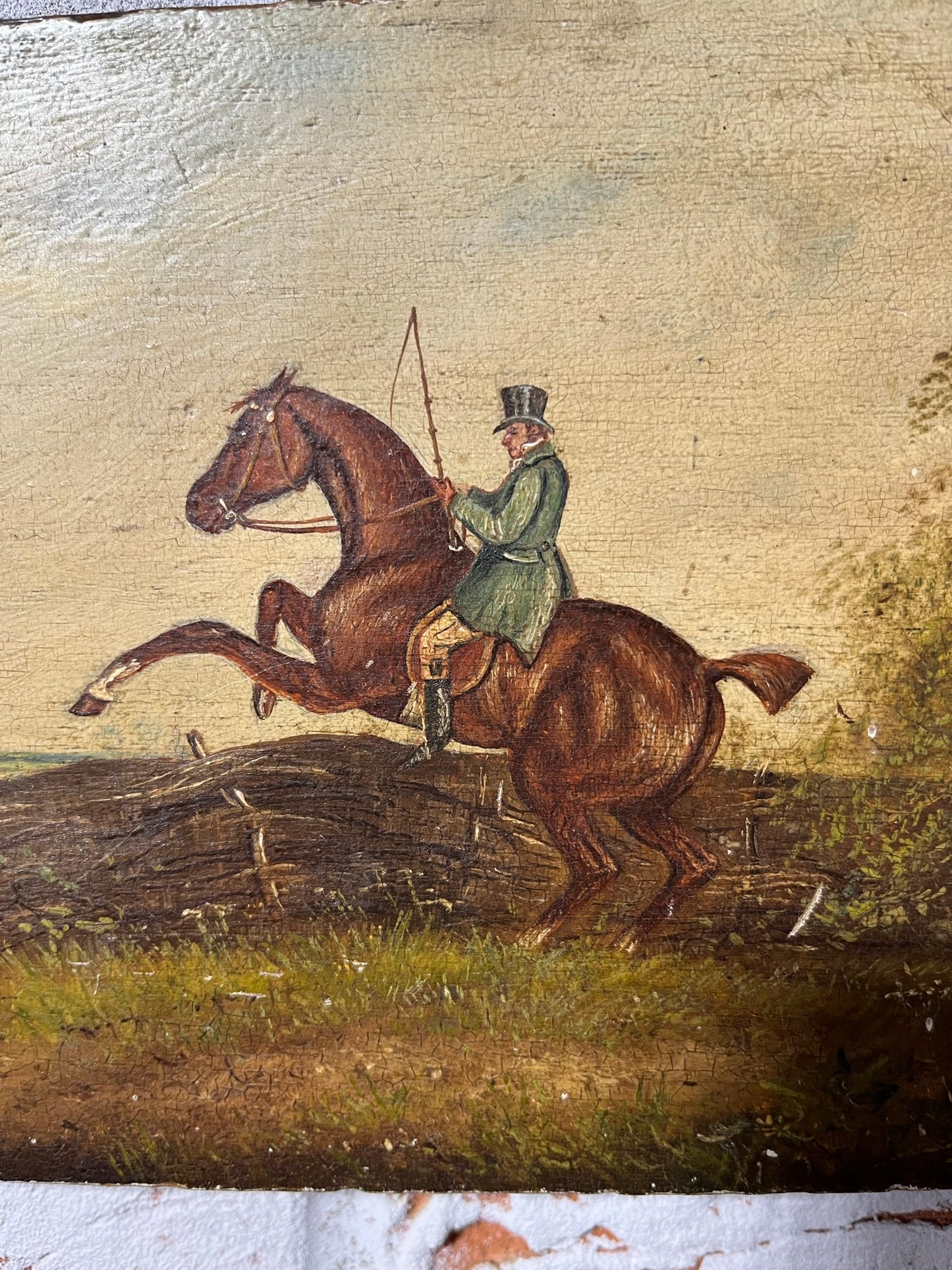 19th century English naive school oil on board of horse and rider taking a fence.