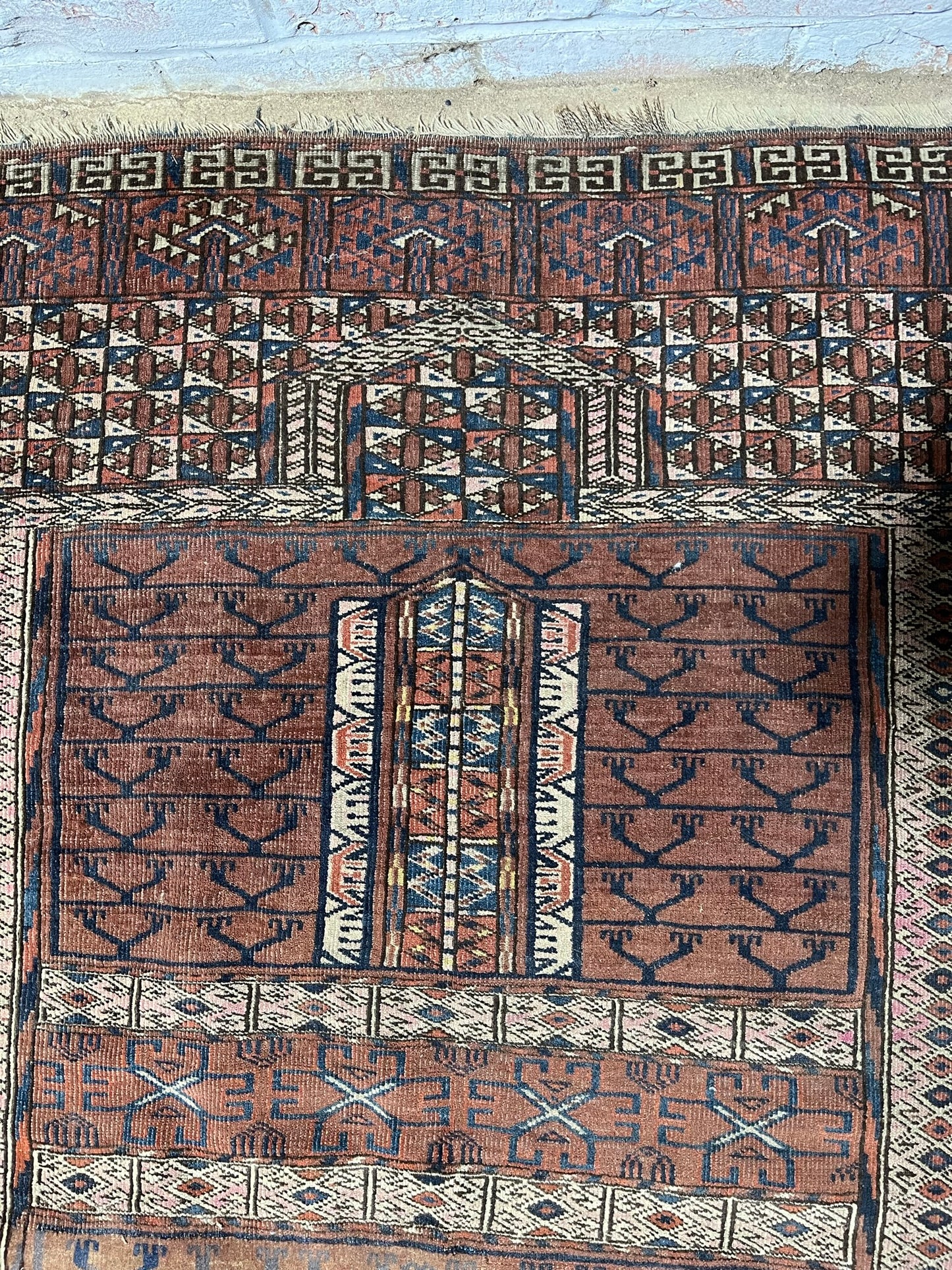 An antique hatchli bokhara rug or door hanging.