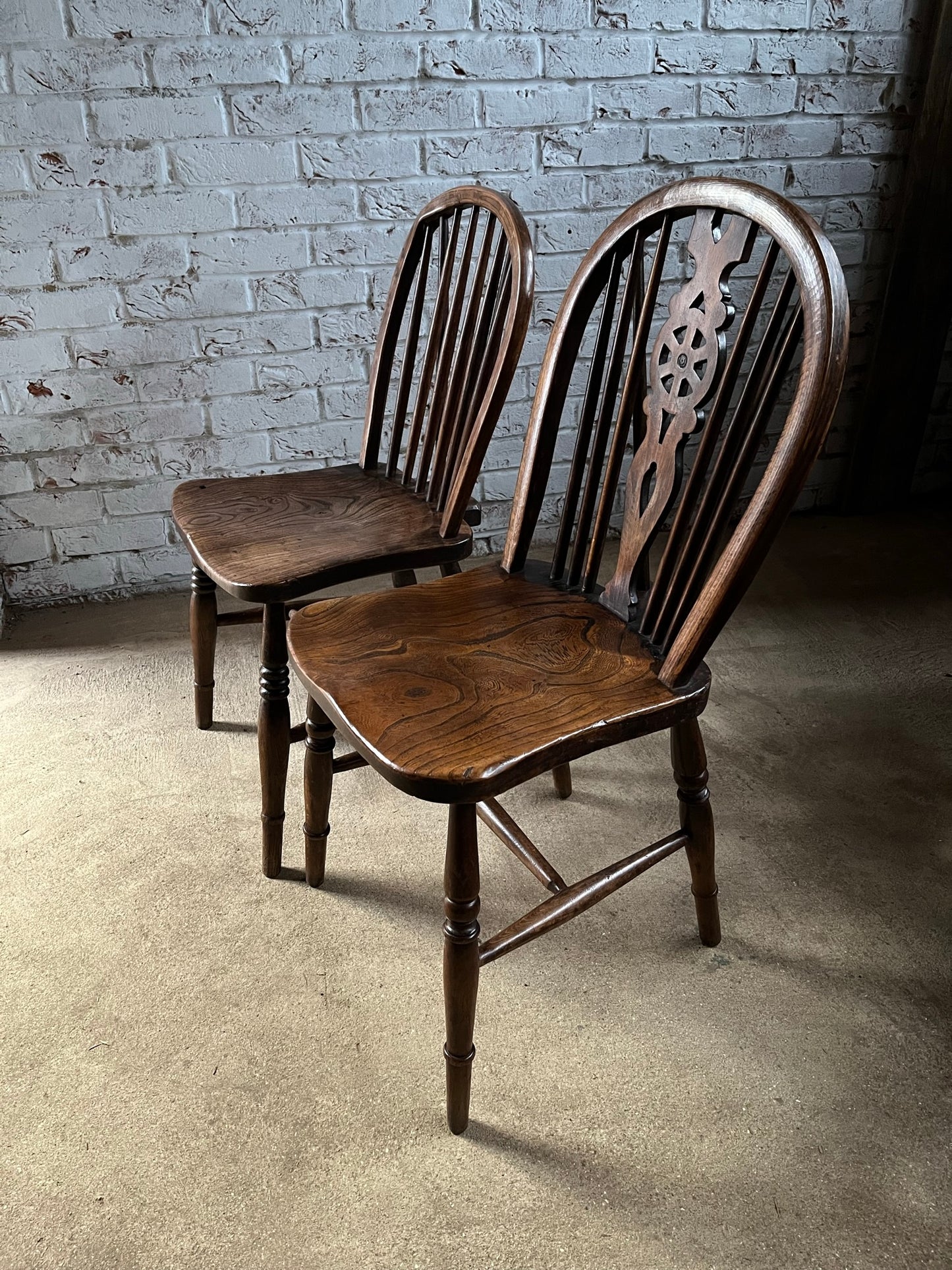 Two 19th century wheel back/stick back kitchen or dining chairs.