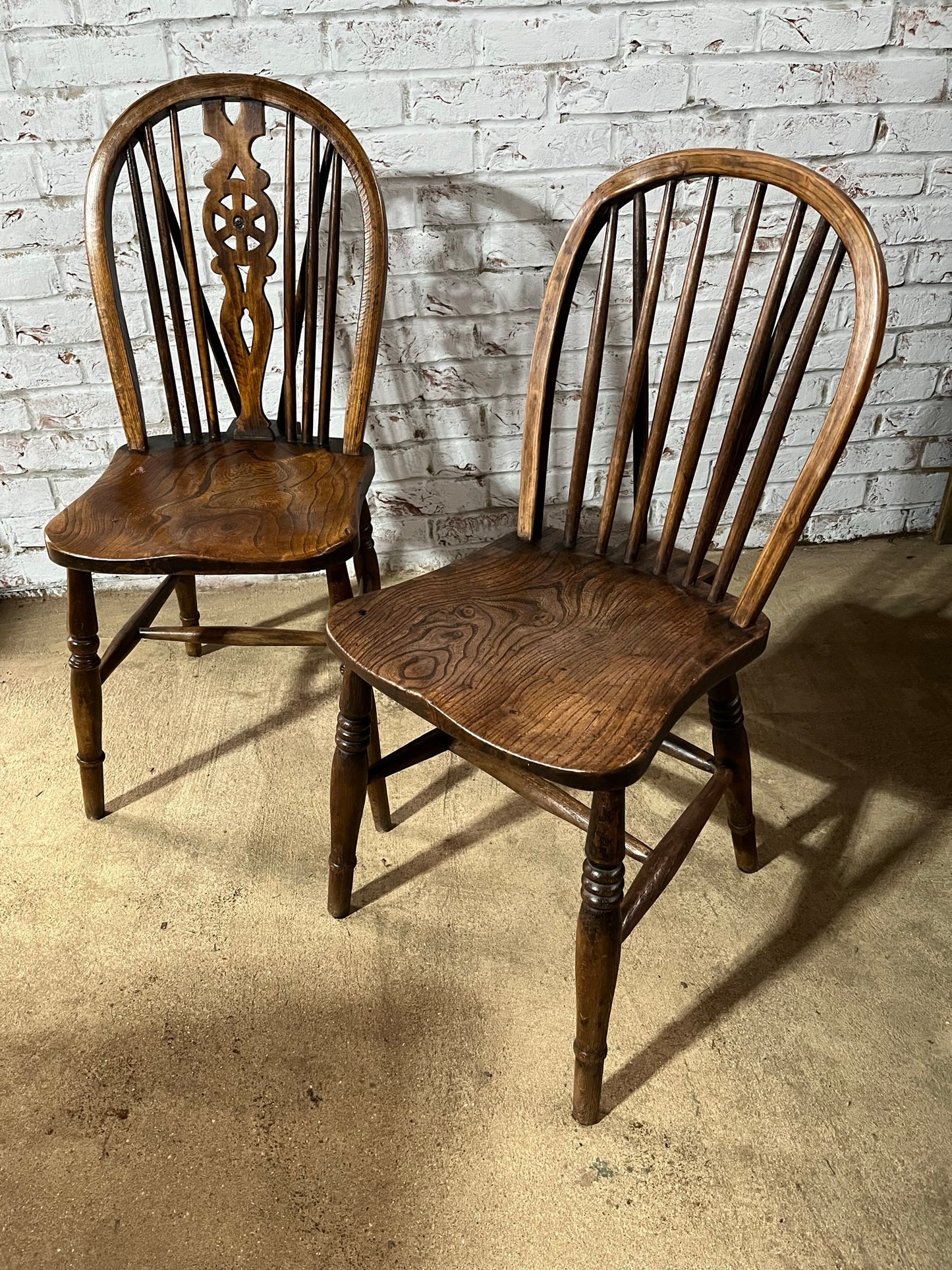 Two 19th century wheel back/stick back kitchen or dining chairs.
