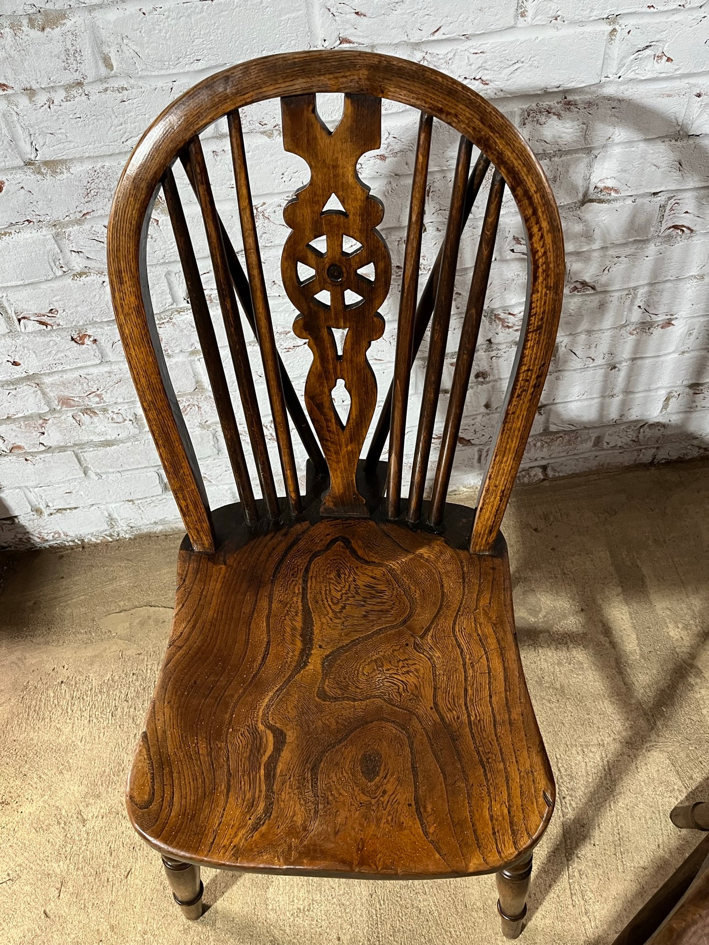Two 19th century wheel back/stick back kitchen or dining chairs.