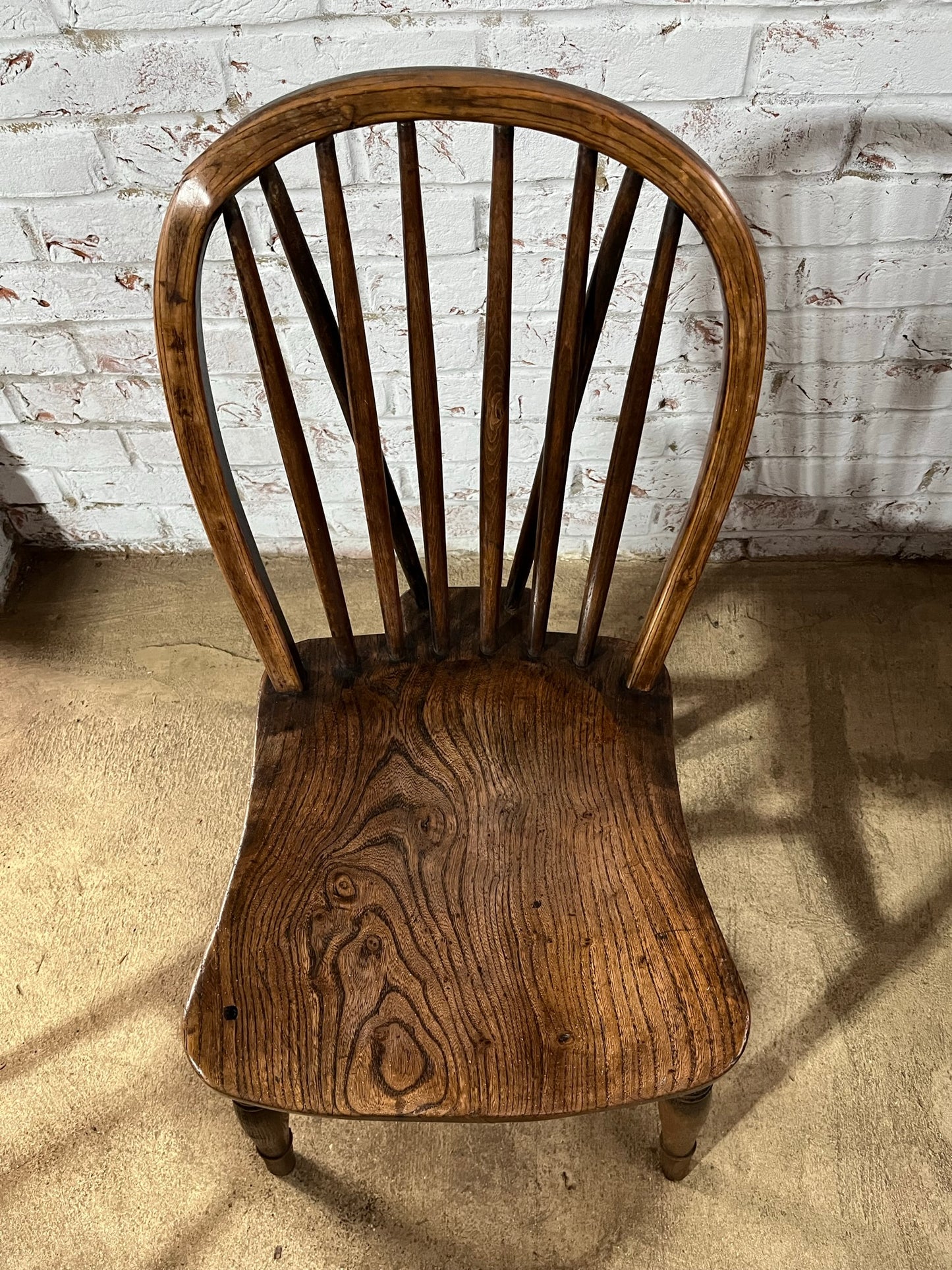 Two 19th century wheel back/stick back kitchen or dining chairs.