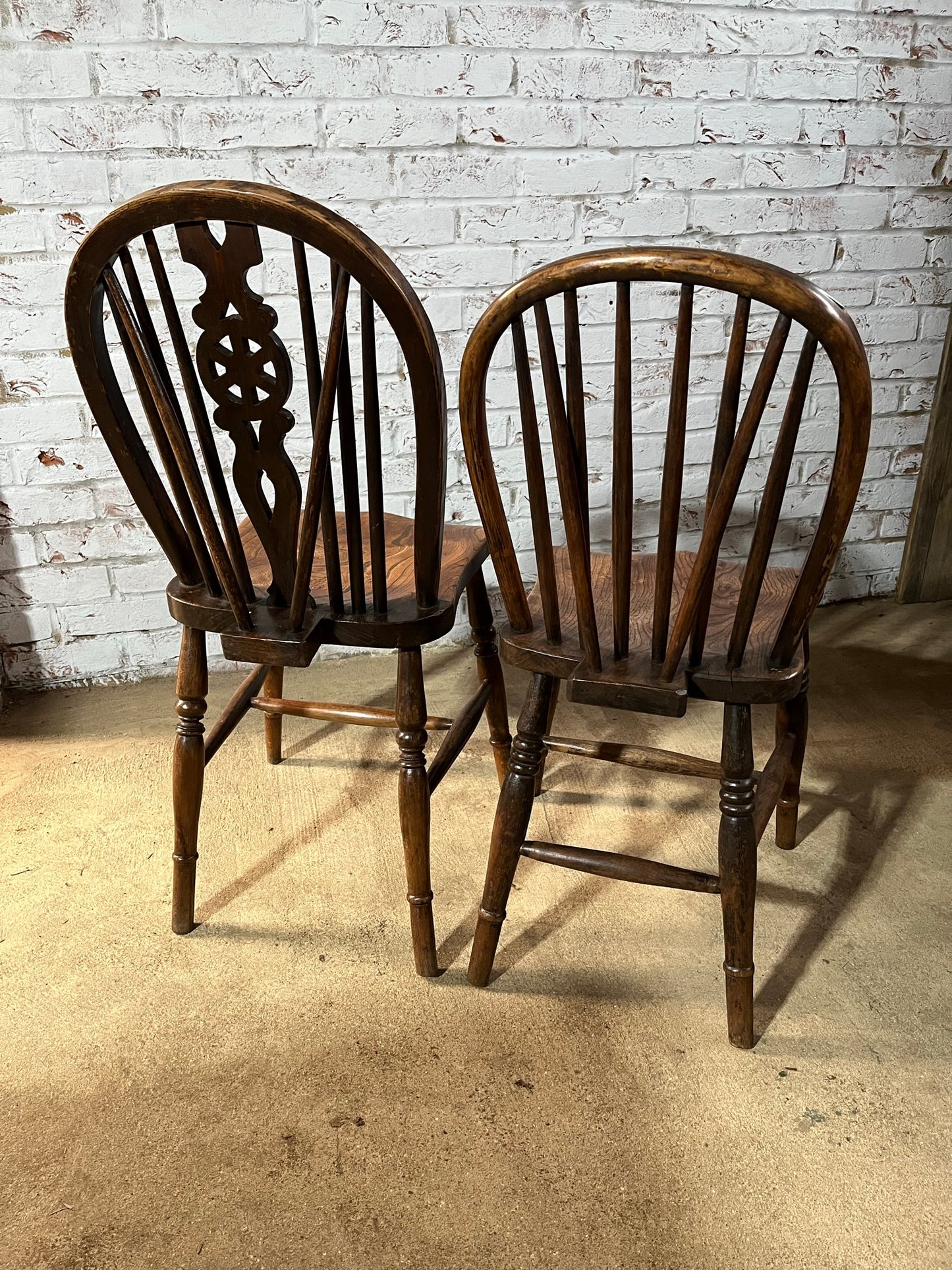 Two 19th century wheel back/stick back kitchen or dining chairs.